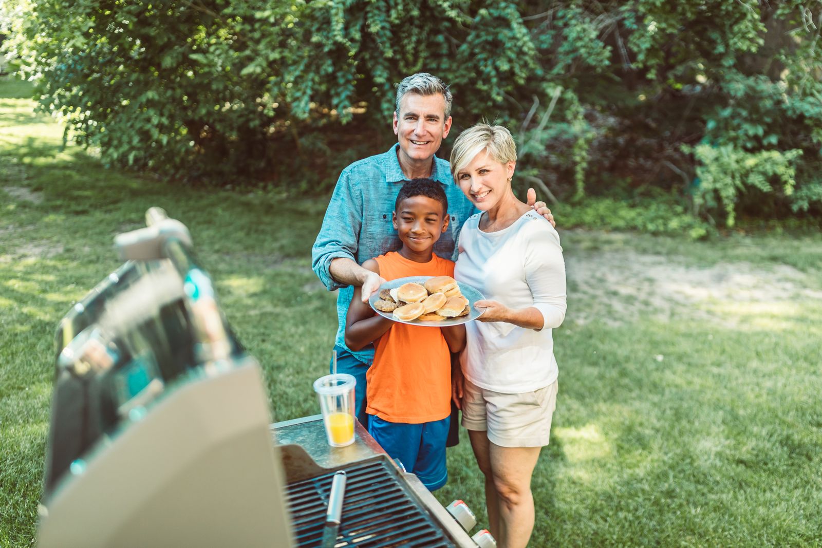 A family around the barbecue in their backyard